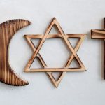 A crescent, star and cross in wood represent three major religions.