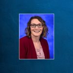 Portrait of a lady wearing glasses, smiling.