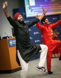 Two individuals are pictured performing an Indian dance.