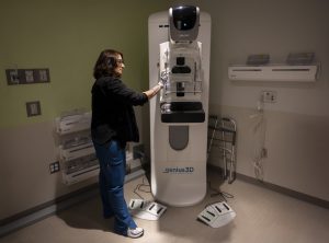 Erin Schaffner, a Penn State Health radiologic technologist, cleans a 3D mammogram machine before a patient screening.