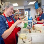 Several Penn State College of Medicine medical students stand in an industrial kitchen baking for the Ronald McDonald House.