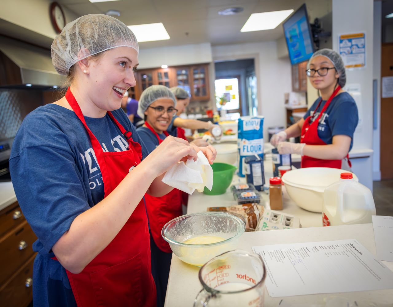 Several Penn State College of Medicine medical students stand in an industrial kitchen baking for the Ronald McDonald House.