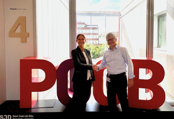 Two people standing next to each other and shaking hands.