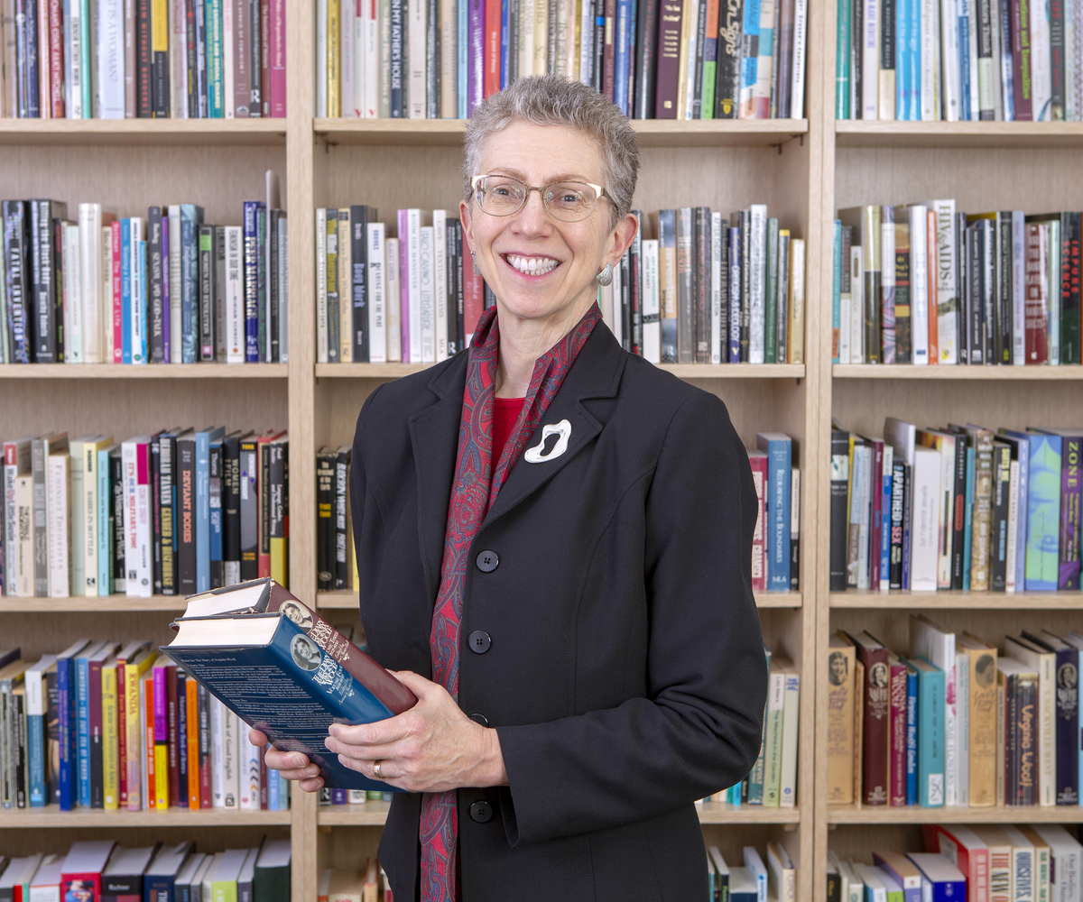Humanities Chair poses in front of bookcase.