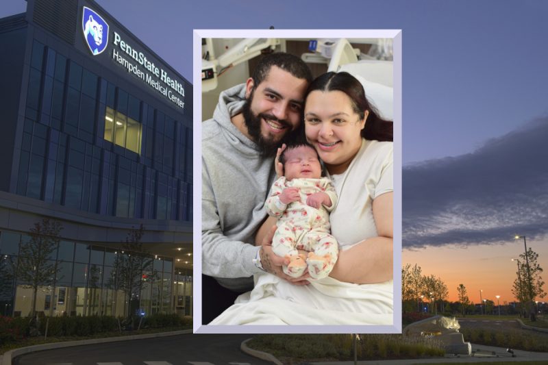 An image of two parents holding a newborn child is placed over a stock image of Penn State Health Hampden Medical Center.
