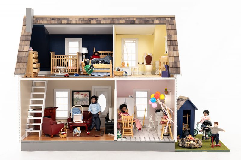 A dollhouse shows common household hazards in the bedroom, bathroom, living room, kitchen and backyard.