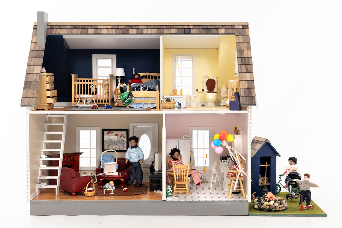 A dollhouse shows common household hazards in the bedroom, bathroom, living room, kitchen and backyard.