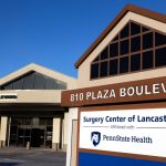 An external photo of Surgery Center of Lancaster, with a sign prominent in the foreground.