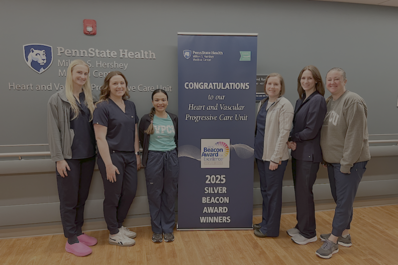 Six people pose around a sign that says, "Congratulations to our Heart and Vascular Progressive Care Unit 2025 Silver Beacon Award Winners."