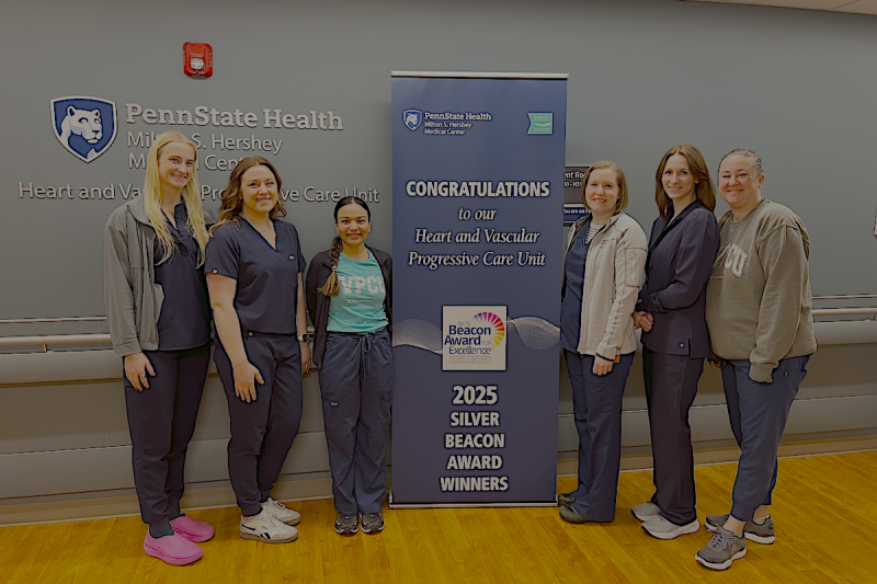 Six people pose around a sign that says, "Congratulations to our Heart and Vascular Progressive Care Unit 2025 Silver Beacon Award Winners."