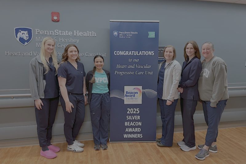 Six people pose around a sign that says, "Congratulations to our Heart and Vascular Progressive Care Unit 2025 Silver Beacon Award Winners."