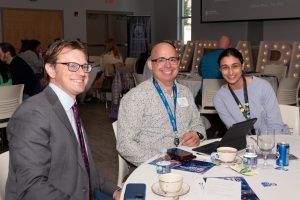 Several people are seated at a table during the awards ceremony.
