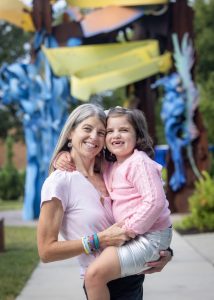 A young child poses with her mother.