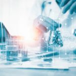 Image of gloved hands working in a hospital's pathology lab analyzing scientific data