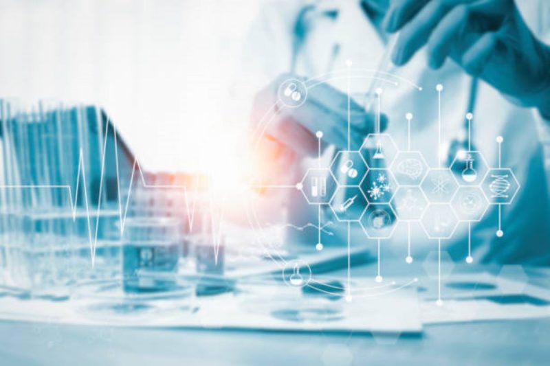 Image of gloved hands working in a hospital's pathology lab analyzing scientific data