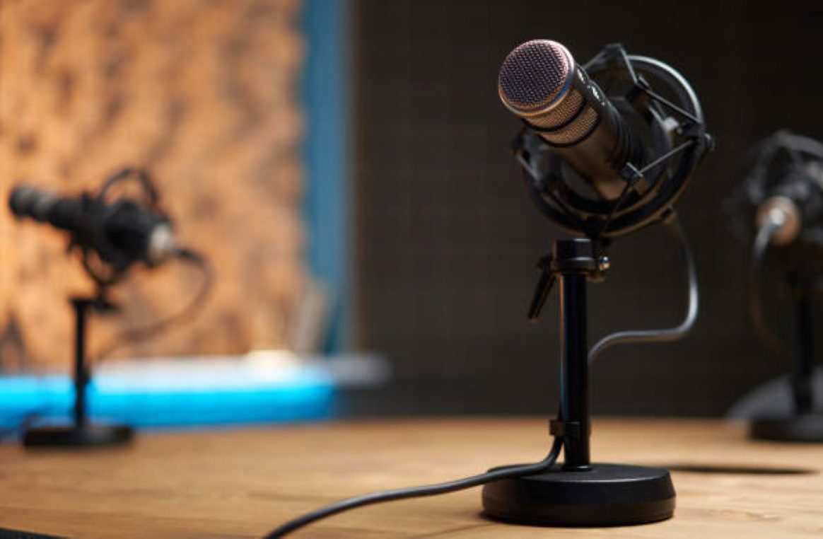 A podcast microphone on a desk in a recording studio