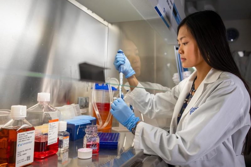 Person using a pipette in a lab.