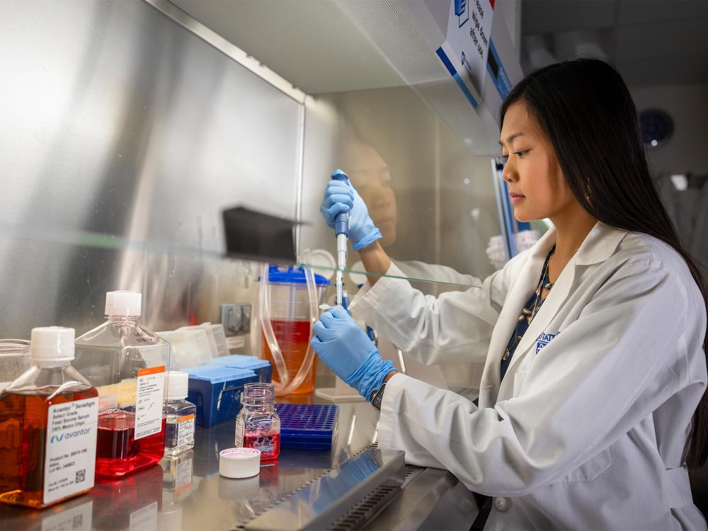 Person using a pipette in a lab.
