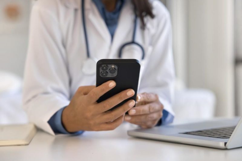 A close-up of a doctor holding a smartphone.