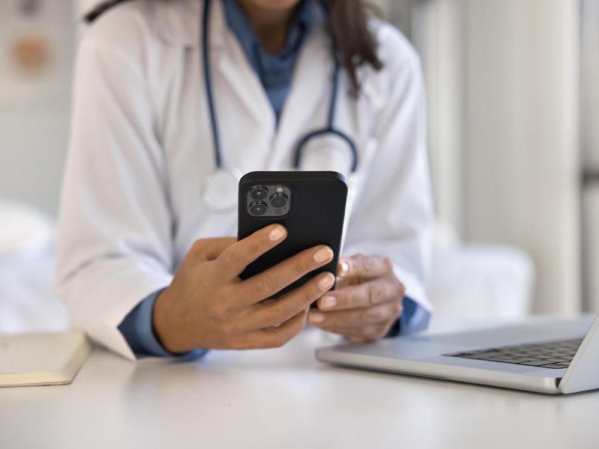 A close-up of a doctor holding a smartphone.