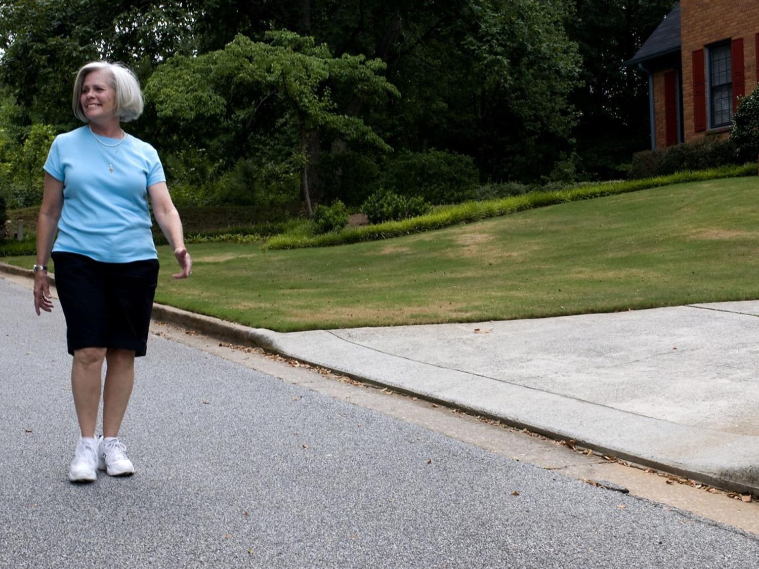 Older woman walking on a sidewalk